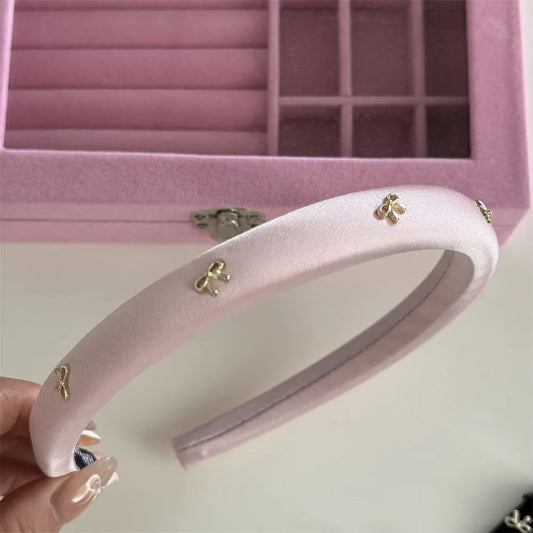 The Béatrice Bow Headband — polished bow headband in gold and pink